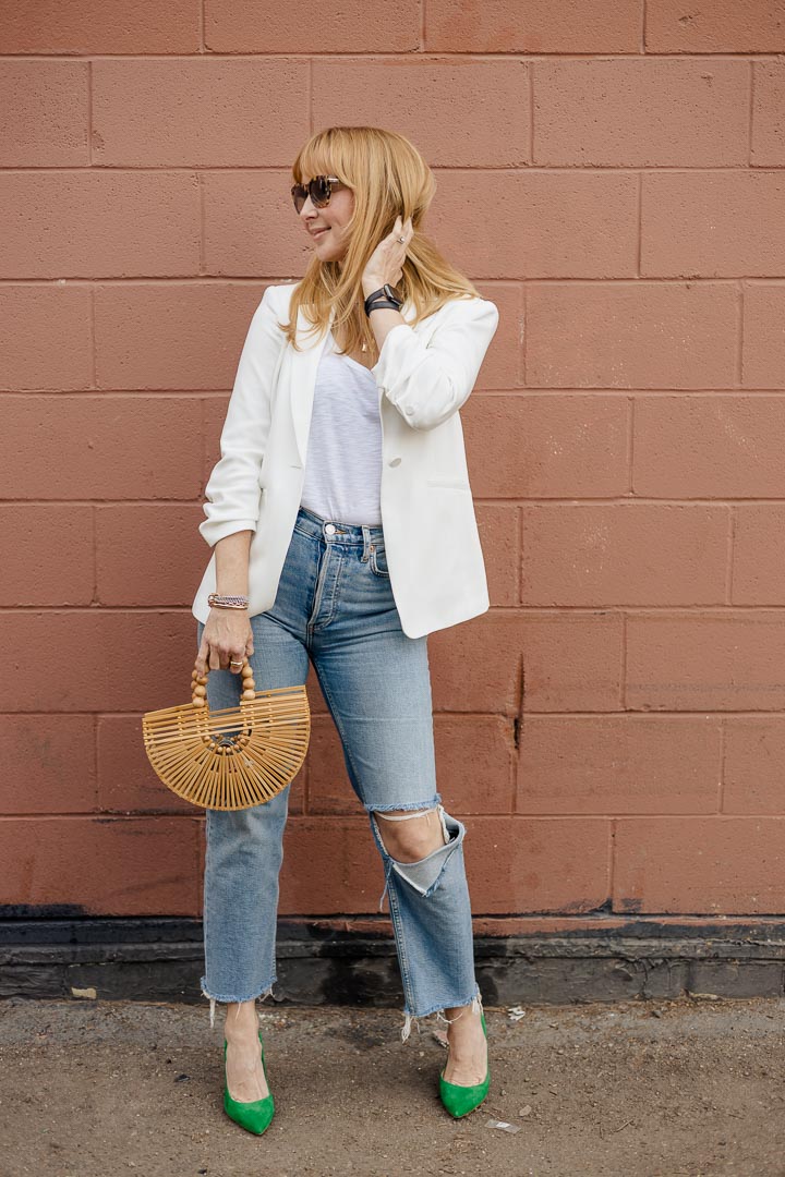 Wearing the Cinq á Sept Khloe blazer in white with REDONE jeans, green Lagence Eloise pumps, and a Cult Gaia mini Ark bag.