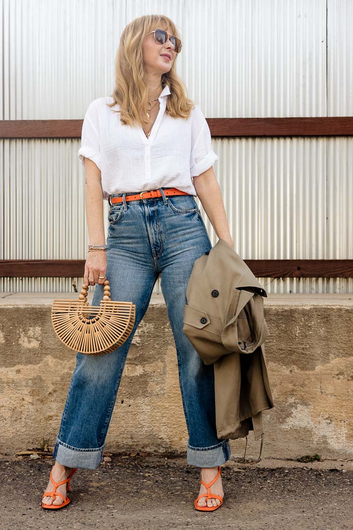 Wearing the XiRENA Cruz shirt in white with MOTHER tunnel vision jeans, and Frame belt and heels in the color orange crush.