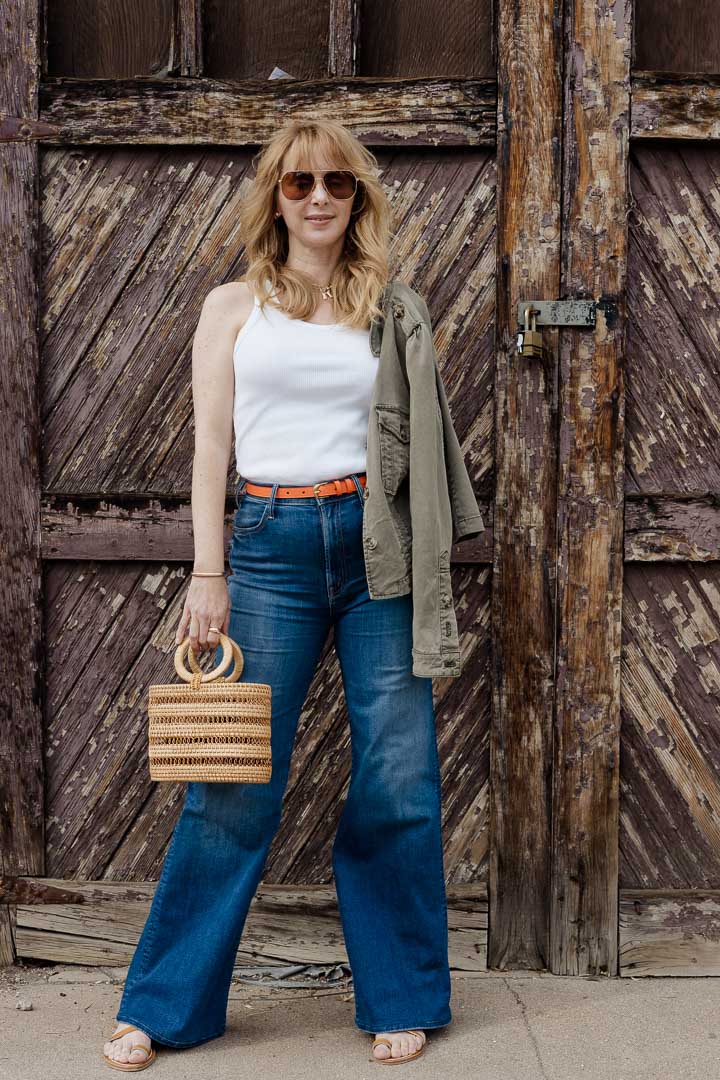 Wearing the MOTHER Hustler Roller jeans with a Frame belt in orange crush, Agolde tank, and Cult Gaia mini Coco tote.