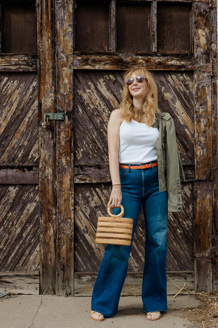 Wearing the MOTHER Hustler Roller jeans with a Frame belt in orange crush, Agolde tank, and Cult Gaia mini Coco tote.