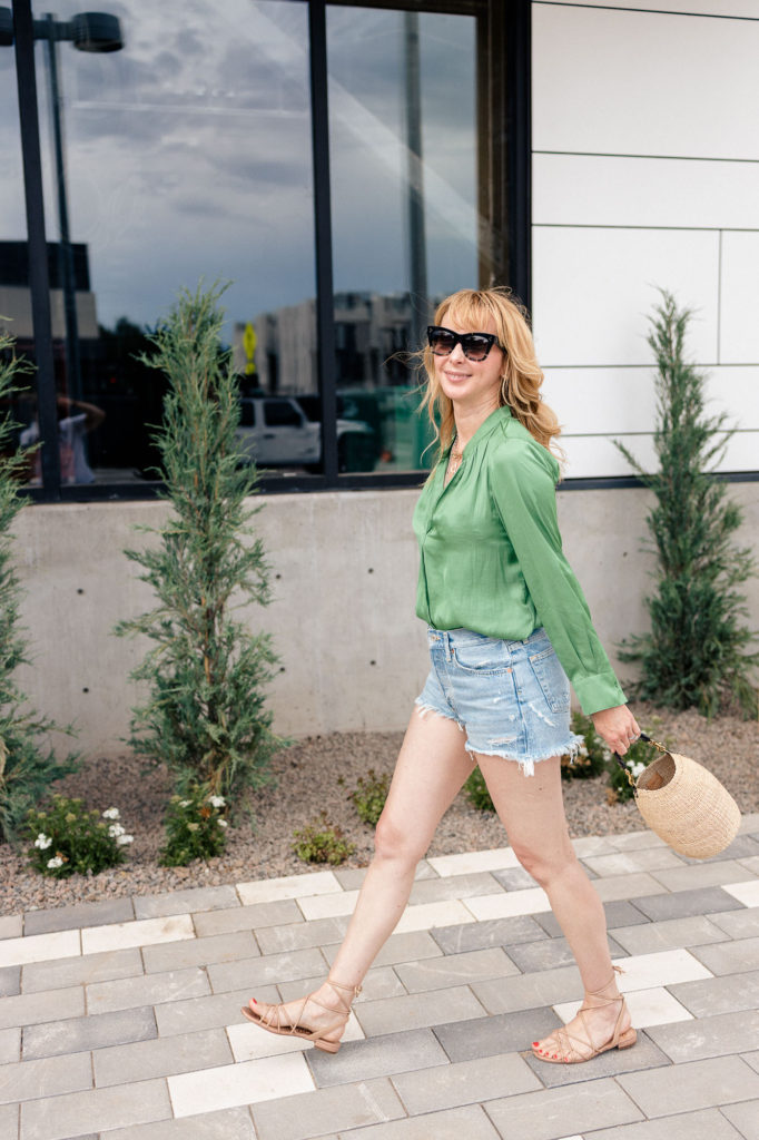 Wearing a green silk Zadig et Voltairer blouse with cutoff Agolee shorts and sandals.