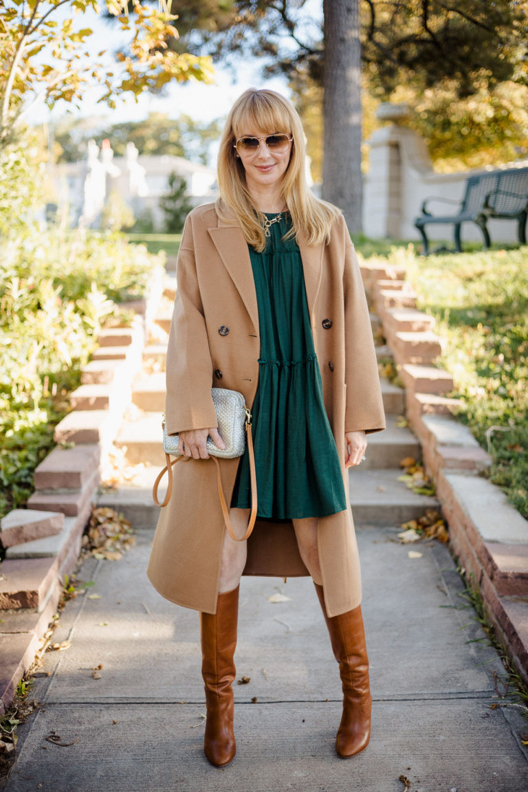 Wearing a under $100 dress in green by Moon River that is perfect for Fall and the holidays with cognac Loefler Randall boots and a camel Anine Bing coat.