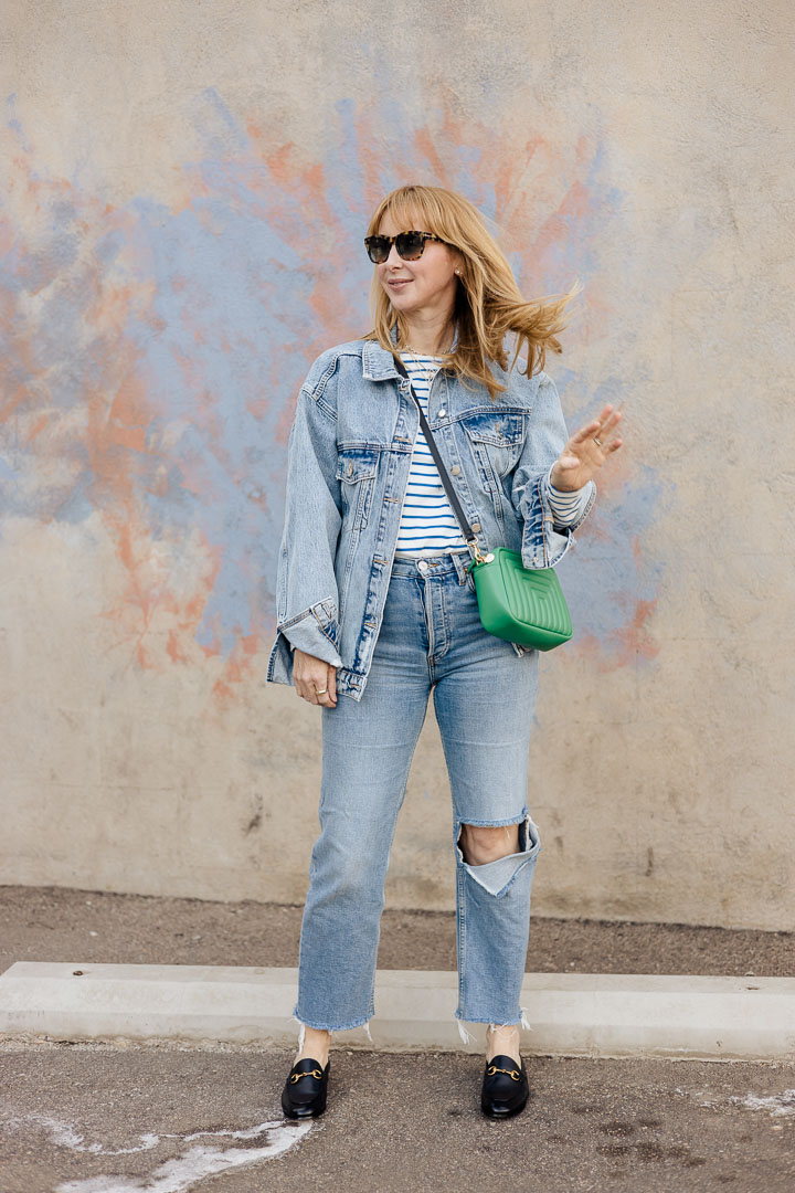 Wearing the Anine Bing Rory oversized denim jacket with a striped tee by KULE, Redone jeans, black Gucci loafers, and a green Clare V. bag.