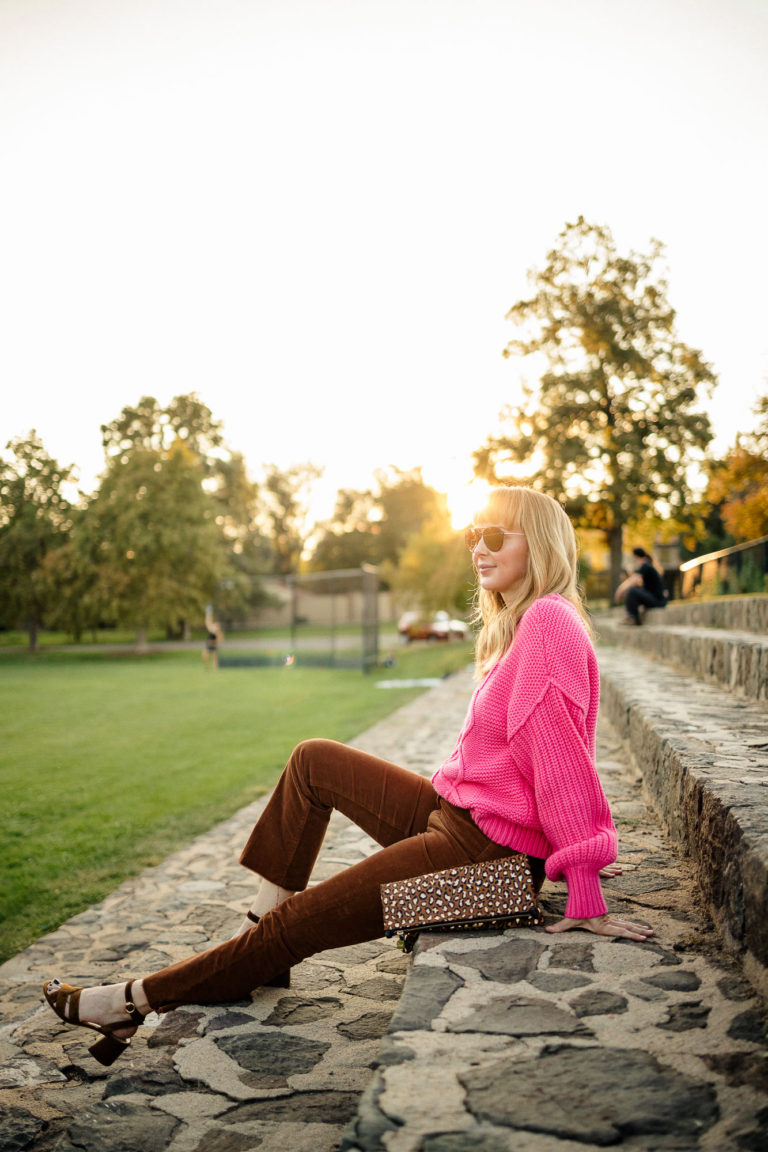 Wearing the Mother Corduroy pants in Monks Robe (brown) with a fuchsia cable knit sweater by Free People.