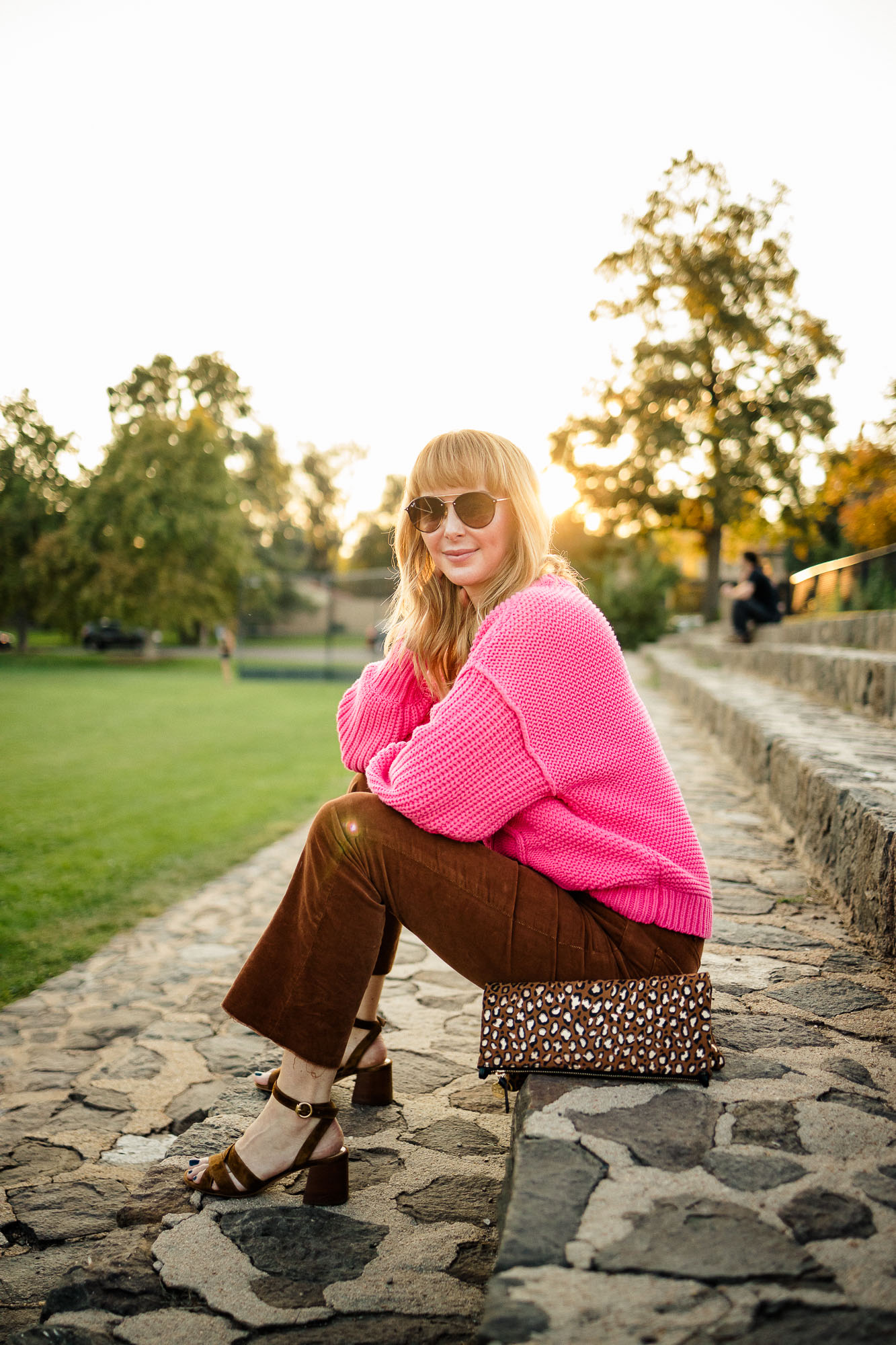 Wearing a fuchsia Free People cable knit sweater with Mother brown corduroy pants and a leopard Clare V bag.