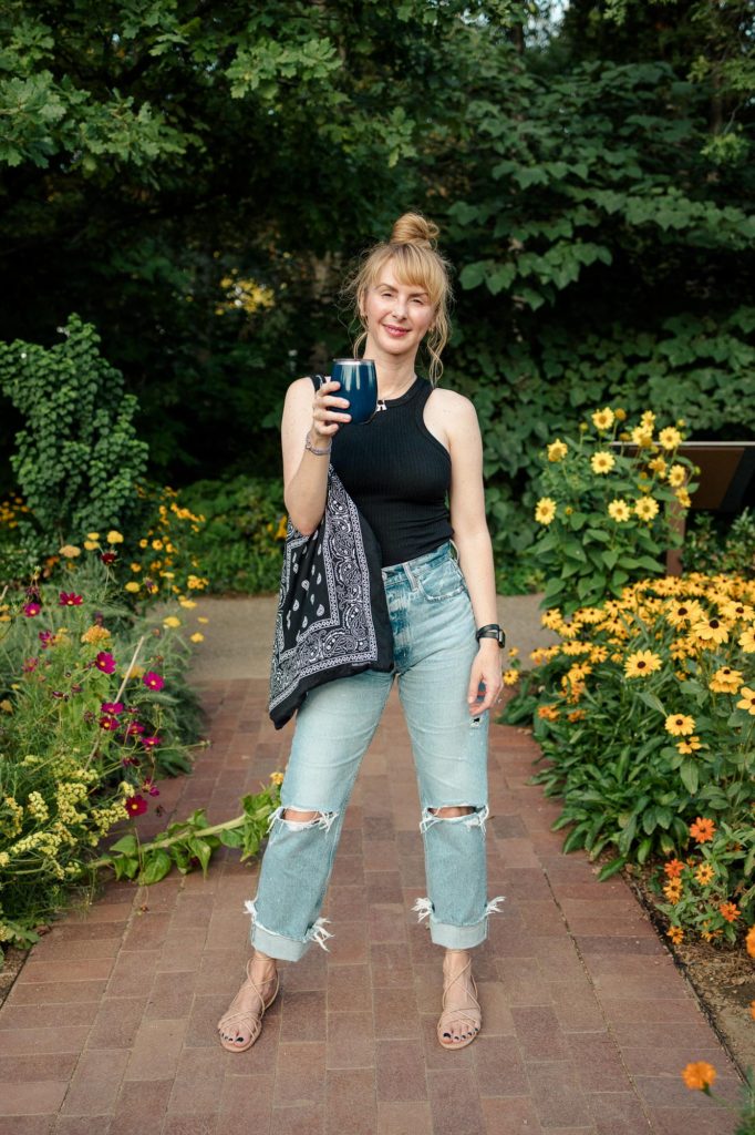 Saks Friends and Family sale - wearing a black LNA tank with distressed Moussy jeans, nude sandals and a black bandana Arizona Love tote at the Denver Botanic Gardens.