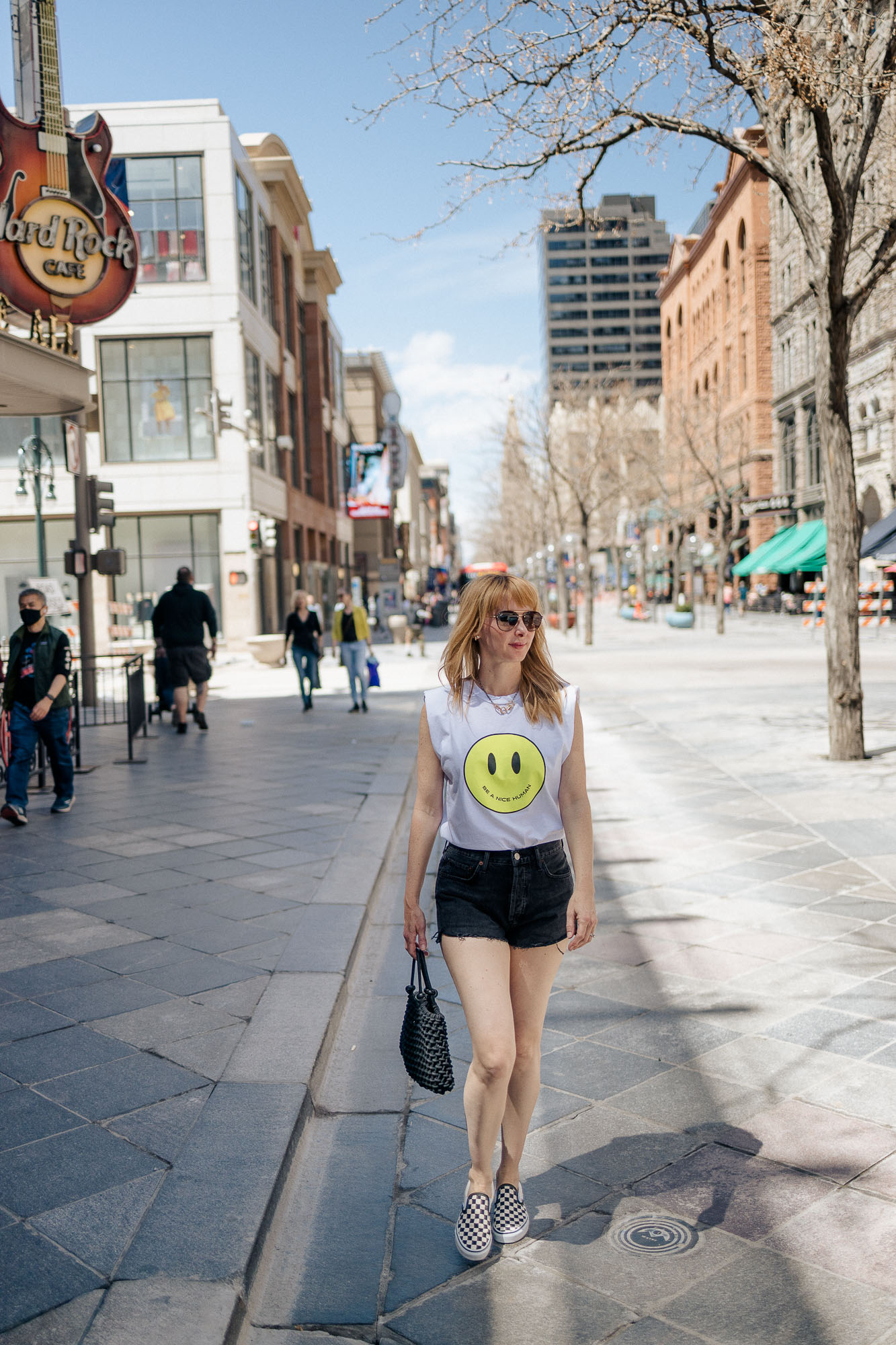 Walking downtown the Le Superbe smiley face tee, black Agolde shorts, and checked classic Vans.