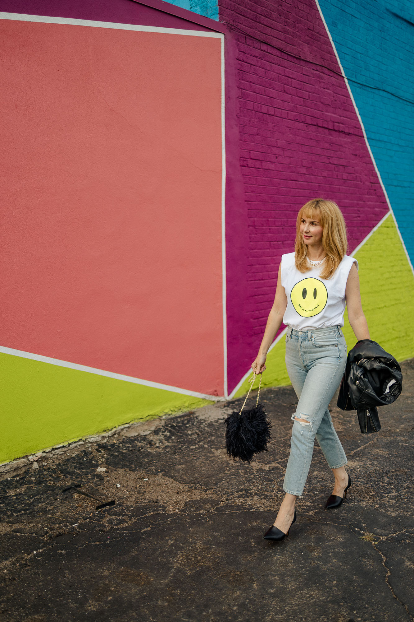 Walking by an 80s mural in the le superbe smiley face graphic tee with shoulder pads.