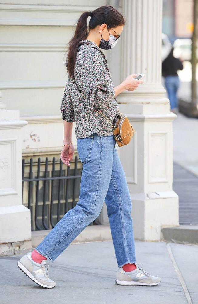 Katie Holmes showing how to wear sneakers stylishly with pink socks and a floral blouse.