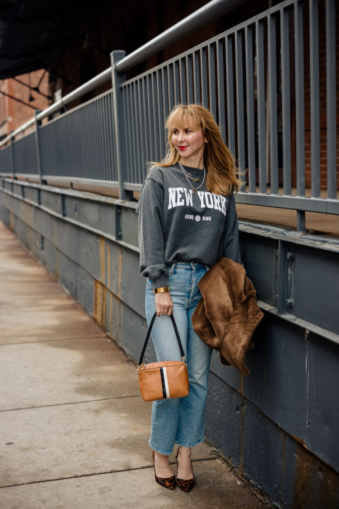 Waring the Anine Bing New York sweatshirt with Mother jeans and L'agence leopard pumps with a Clare V bag.