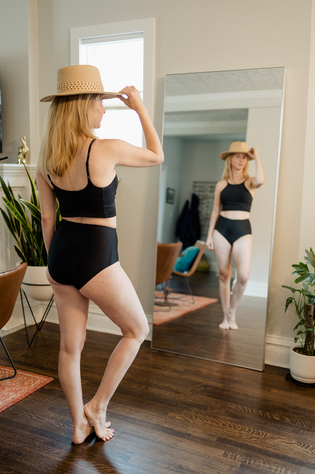 Wearing a hat and two piece Lululemon swimsuit in black.