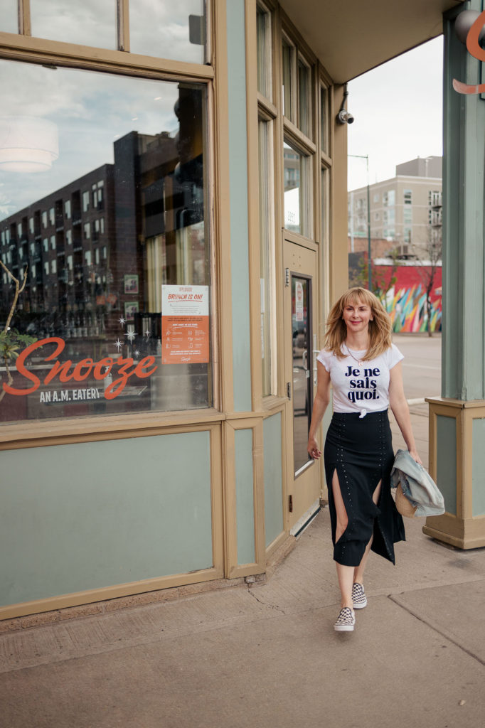 Wearing a black maje studded skirt with a black graphic zadig et voltaire tee in front of Snooze eatery Denver.