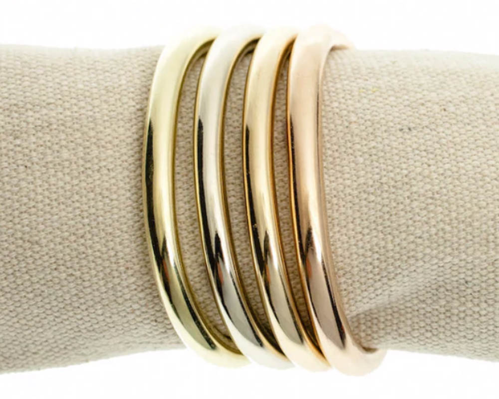 Marla Aaron cuffling stack in brass, gold, and silver.