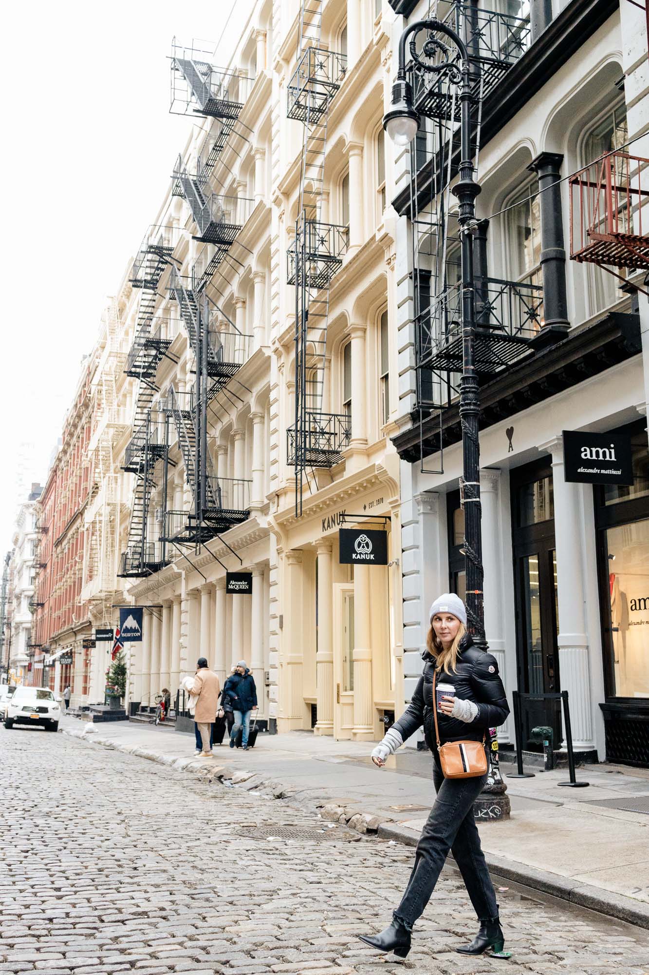 Wearing the Moncler Lannic Puffer, Clare V crossbody and Frame Le Lexington boots in black in Soho NYC.