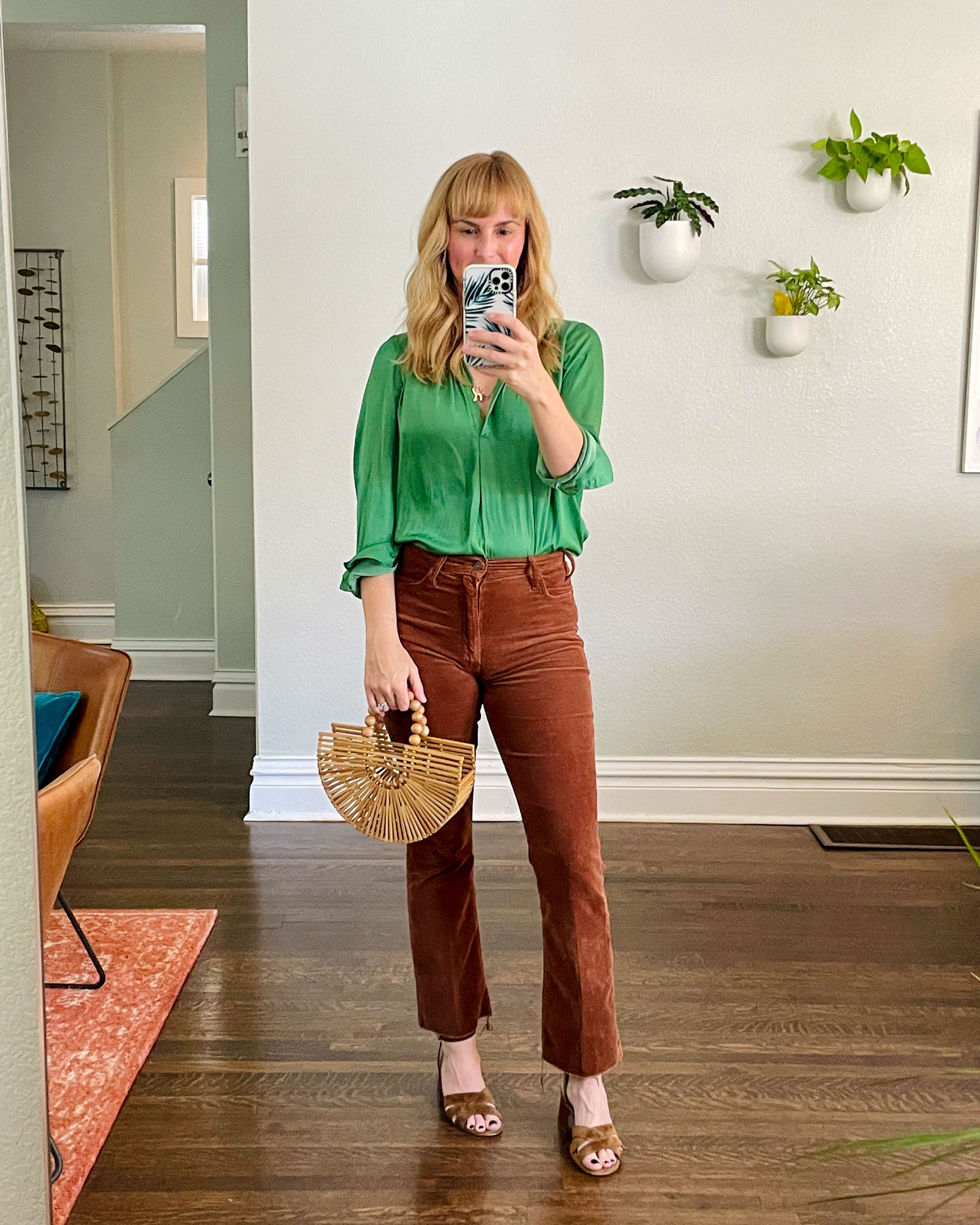 Wearing the Mother Hustler corduroy pants in brown with a green satin shirt by Zadig.