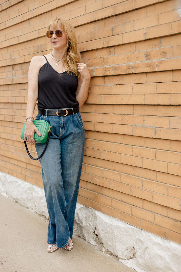 Wearing the Nili Lotan Flora jeans with an Anthony ATM black camisole and green ClareV crossbody bag.