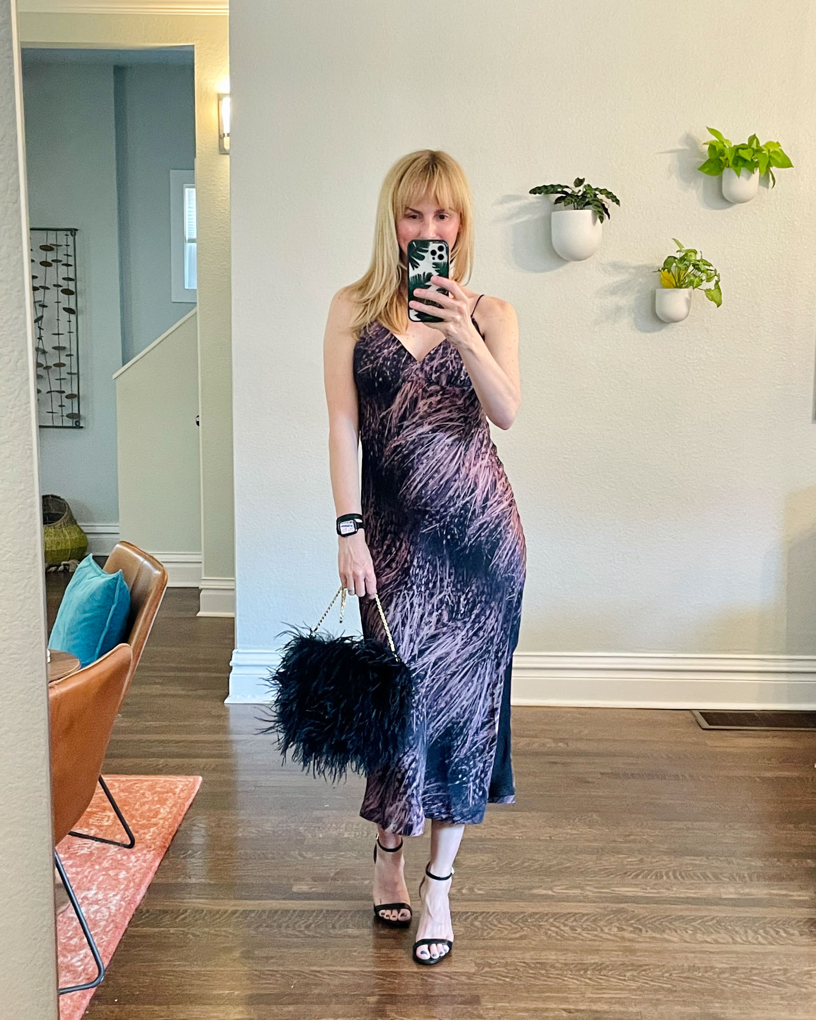 Wearing the Allsaints Melody slip dress with black heels and a feather bag.