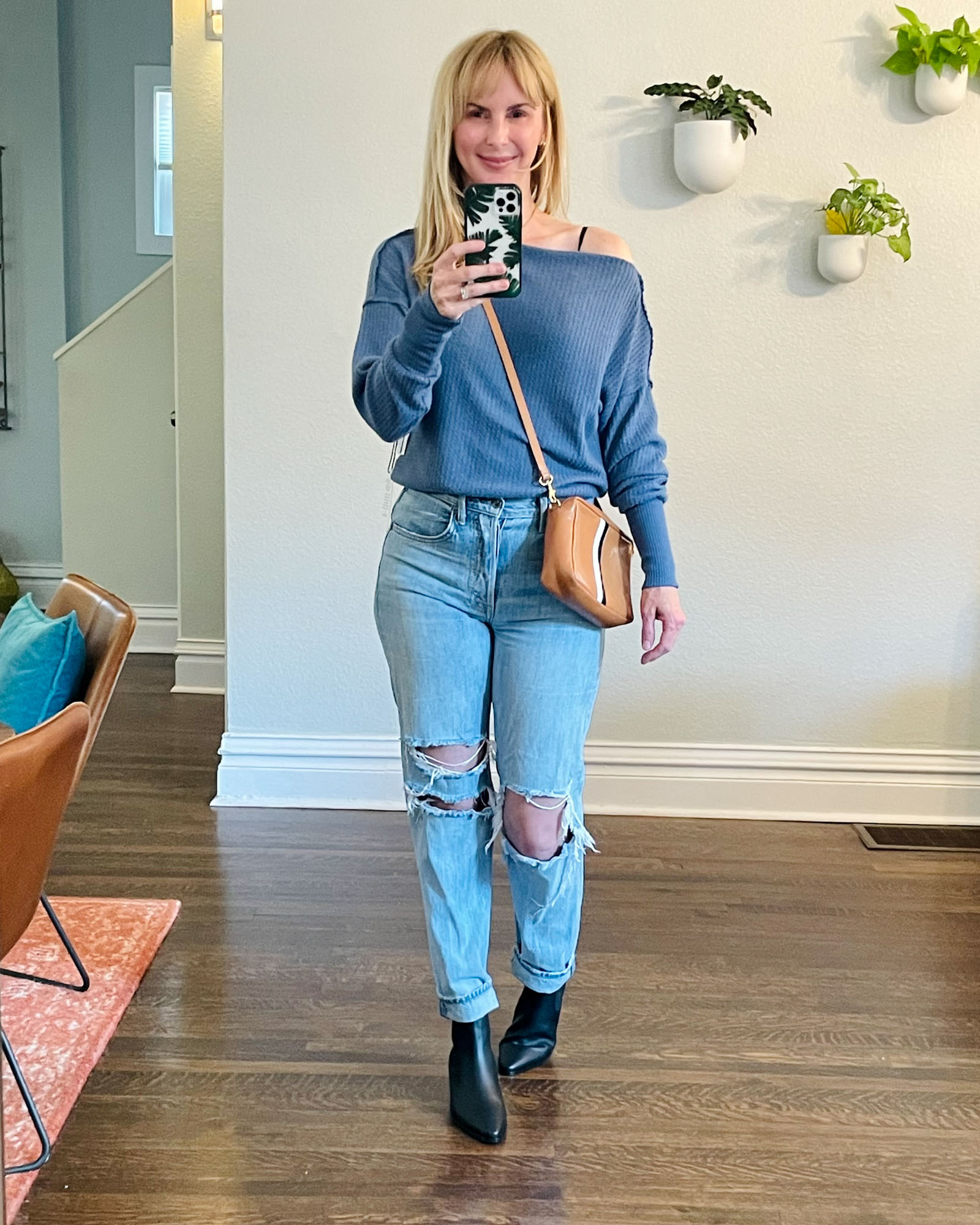 Wearing the Treasure and Bond off the shoulder waffle knit top in blue with ripped jeans and Frame chelsea boots.
