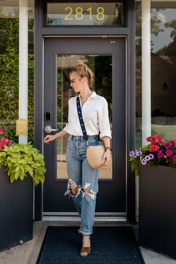 Wearing a stripe linen Reformation button down with distressed Agolde 90s jeans and a Clare V bag.