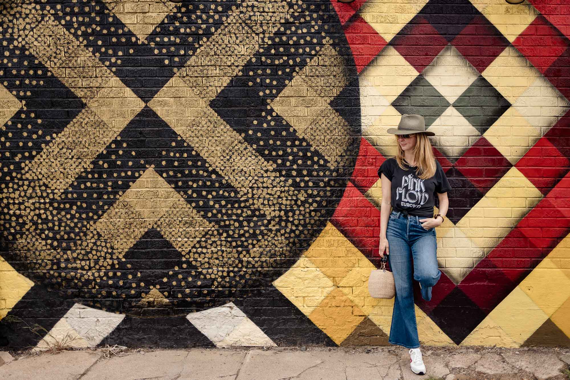 Standing in front a Denver street art mural with my green Rag and Bone fedora and MOTHER Roller jeans.