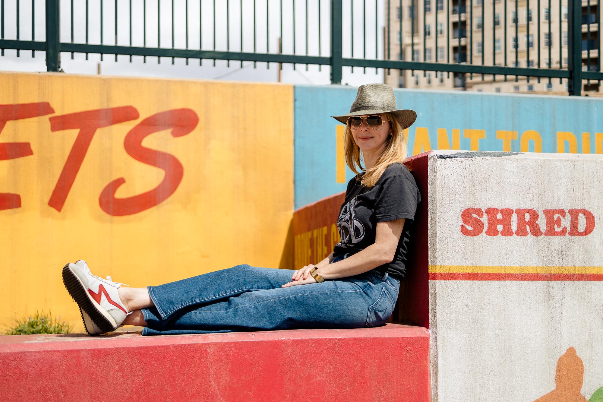 Sitting on a wall in my Rag and Bone green fedora, MOTHER roller jeans and red retro sneakers.