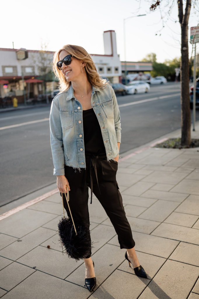Styling the L’Agence Janelle denim jacket for spring with all black jumpsuit from Ramy Brook and Theory, paired with statement bag Loeffler Randall feather crossbody.