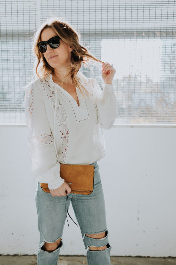 Tammy standing in the Nordstrom parking lot wearing Reiss Dottie top, Grlfrnd Isabeli ripped jeans, Chanel sunglasses, and Zadig Rock suede bag.