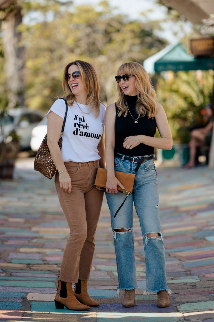 Two friends hanging out at Balboa Park wearing chic casual transitional outfits.