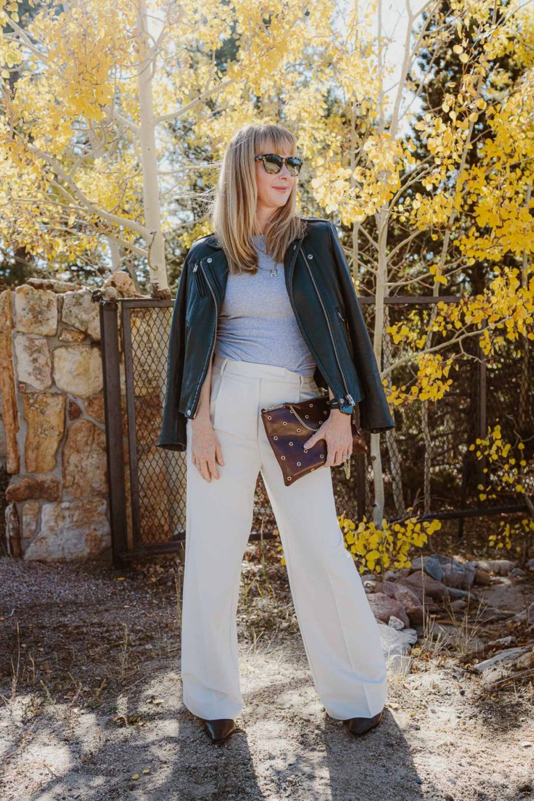 Wearing Zara menswear pants in cream with a gray Anine bing tank and black Iro leather jacket in front of aspen trees changing color.